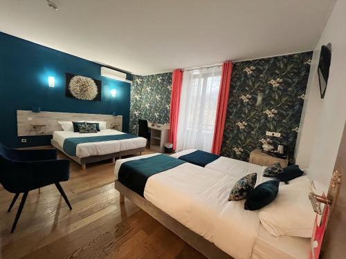 une chambre d'hôtel avec deux lits et un bureau dans l'établissement Empire Hôtel, à Nîmes