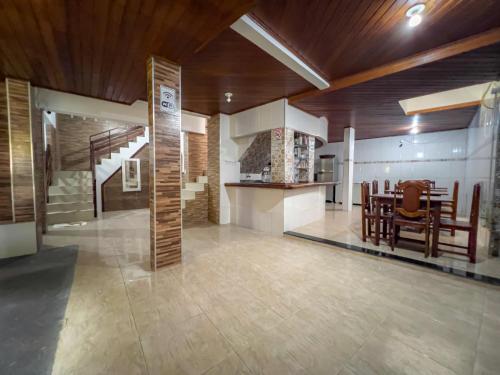 a living room with a staircase and a table and chairs at pousada Vitoria in Morro de São Paulo