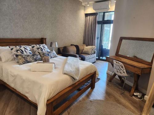 ein Schlafzimmer mit einem großen Bett und ein Wohnzimmer in der Unterkunft Stunning Apartment in The Capital Trilogy Menlyn Maine Residences - Apartment 721 in Pretoria