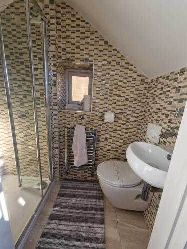 a bathroom with a toilet and a sink at Redwing Rise in Royston