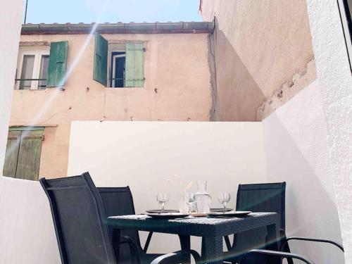 - une table avec des verres à vin assise sur un balcon dans l'établissement Vermeille: Terrasse calme au coeur du village, à Port-Vendres
