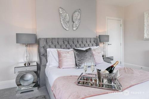 a bedroom with a bed with a tray of wine bottles at Glamorous 2-bedroom, Central location, Scenic Views - Central Park Suite in Parkstone