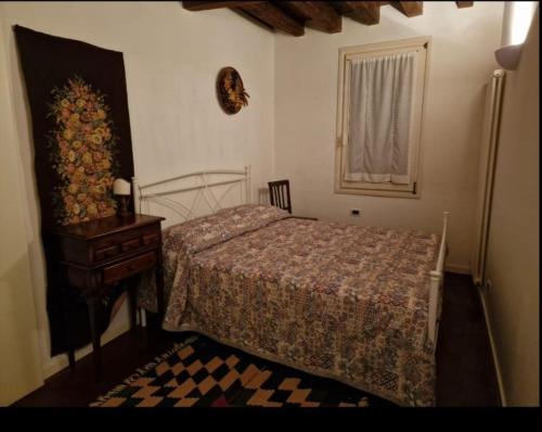 een slaapkamer met een bed, een tafel en een raam bij Ca della Pietà in Venetië