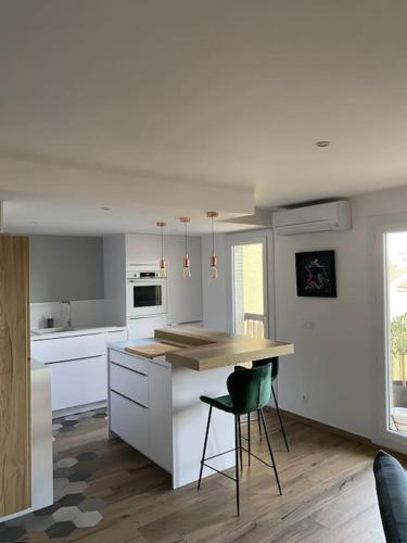 une cuisine avec des armoires blanches et un comptoir en bois dans l'établissement Cocon idéalement situé entre terre et mer, à Argelès-sur-Mer