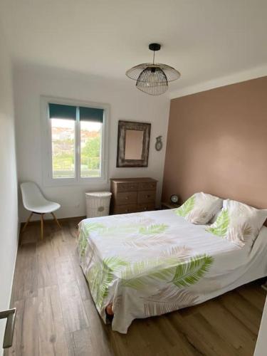 une chambre avec un grand lit et une chaise dans l'établissement Cocon idéalement situé entre terre et mer, à Argelès-sur-Mer