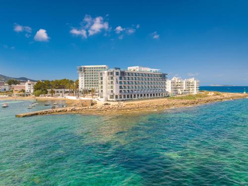 a view of a beach with buildings and the water at Amàre Beach Hotel Ibiza - Adults Recommended in San Antonio Bay