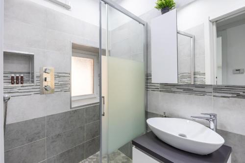 a bathroom with a sink and a glass shower at 6 MINUTI AIRPORT ORIO AL SERIO, VISTA FIUME E Wifi in Seriate