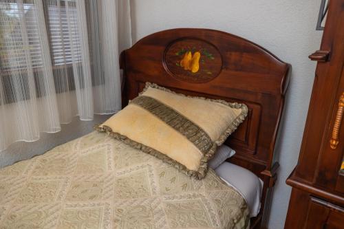 a bed with a wooden head board with a pillow at Etno selo Stanišići Hotel Pirg in Dvorovi