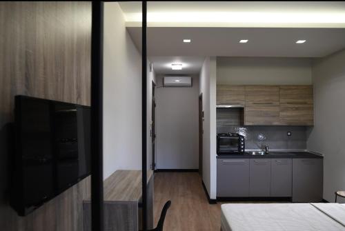 a small room with a kitchen and a room with a bed at Avenue Luxury Apartments in Alexandroupoli
