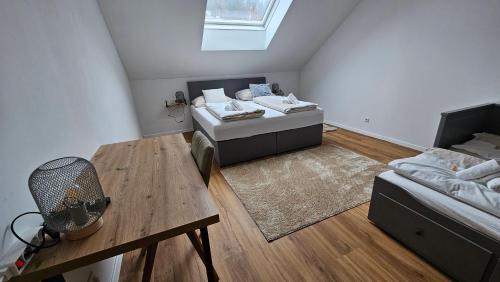 a attic room with two beds and a table at Christians Alpenparadies in Bad Mitterndorf