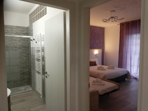 Cette chambre comprend deux lits et une salle de bains pourvue d'une douche. dans l'établissement La Dea Rooms, à Ferrare