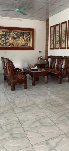 Hotel Thuý đông في Sóc Sơn: غرفة معيشة مع أثاث خشبي وطاولة