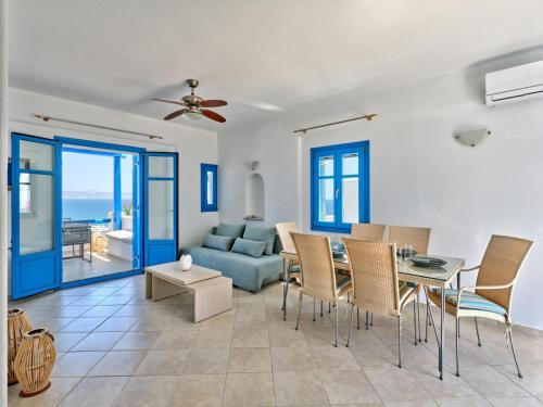 een woonkamer met een bank en een tafel en stoelen bij Paros Luxury Villa 2mins from the beach in Piso Livadi