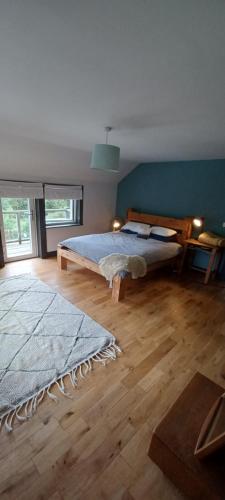 een slaapkamer met een groot bed en een houten vloer bij Shanti ghar house in Cork