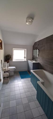 een badkamer met een bad, een toilet en een wastafel bij Shanti ghar house in Cork