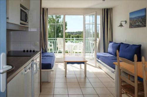 een keuken en een woonkamer met een bank en een tafel bij "L'ÉVASION Ô SOLEIL" Appartement 4 personnes, vue dégagée sur le golf, accès parc aquatique gratuit in Talmont
