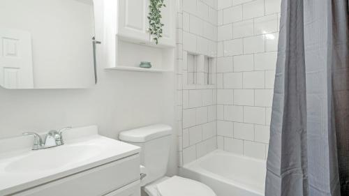 Baño blanco con aseo y lavamanos en Charming Homey Midtown Oasis W/Tropical Patio en Atlanta