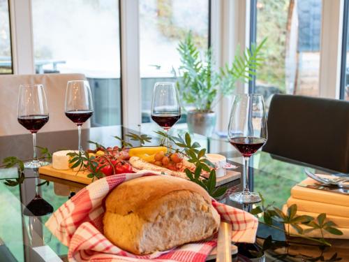 a table with two glasses of wine and a loaf of bread at Ferienhaus Wendelinus mit Pool & Sauna in Hausach