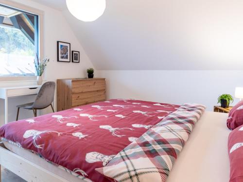 a bedroom with a bed with a red blanket at Ferienhaus Wendelinus mit Pool & Sauna in Hausach