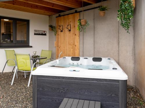 a kitchen with a bath tub with a table and chairs at Ferienhaus Wendelinus mit Pool & Sauna in Hausach