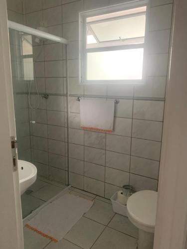 a bathroom with a toilet and a sink at Apto amplo próximo Casa Grande Hotel Resort in Guarujá