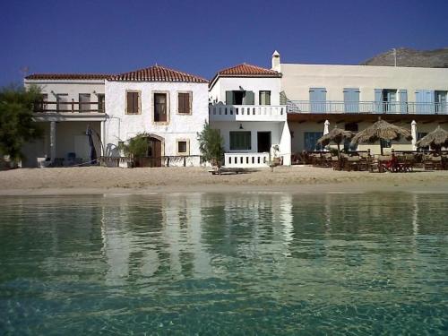 a white house on the beach next to the water at Fishermen Beach House in Dhiakofti