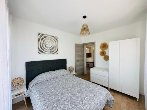 biała sypialnia z łóżkiem i białą szafką w obiekcie LOTI w mieście Antibes