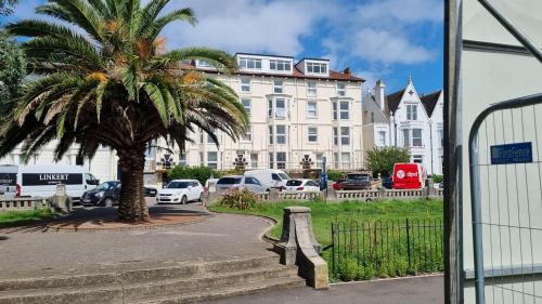 a palm tree in front of a large building at Southsea Escape - 2 double bedrooms - PARKING PERMITS INCLUDED in Portsmouth