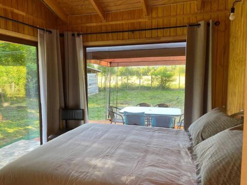 a large bed in a room with a large window at Comodidad y hermosa Vista Volcán in Melipeuco