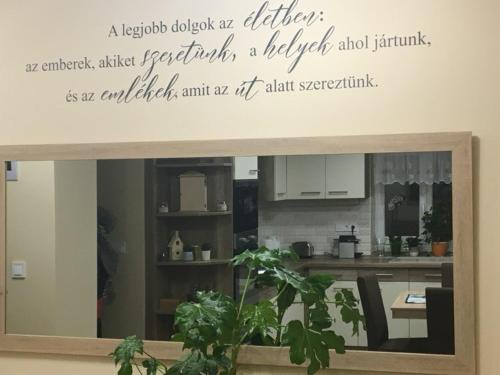 een citaat op een muur boven een keuken met een plant bij HUSZÁR VENDÉGHÁZ in Noszvaj