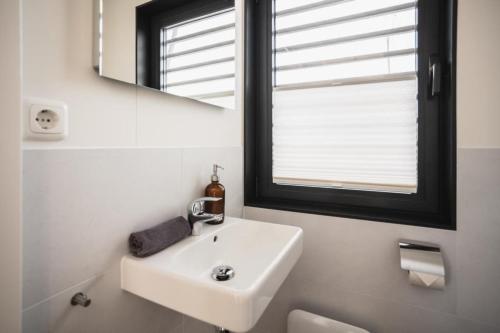 a white bathroom with a sink and a mirror at Hausboot Paradise - LP9 in Peenemünde