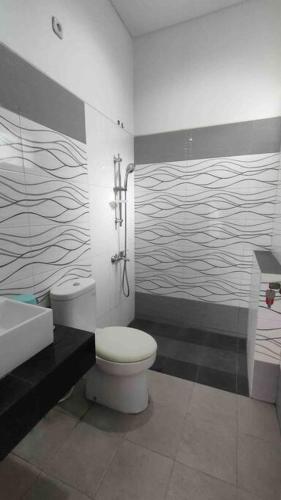 a bathroom with a toilet and a sink and a shower at Green House with Pool in Bonorejo