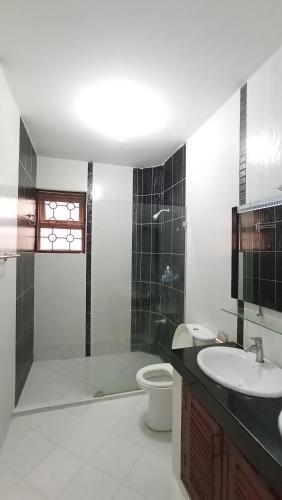 a bathroom with a sink and a shower and a toilet at Baraka Suites, Nyali Gulf Links Apartment by Gash Homestays C-1 in Mombasa