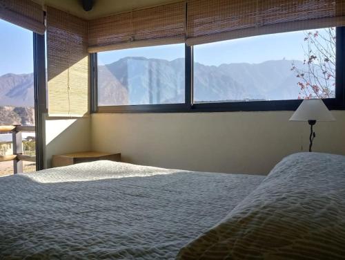 1 dormitorio con cama y vistas a las montañas en La Antonia, cabaña al pie de la montaña en Luján de Cuyo