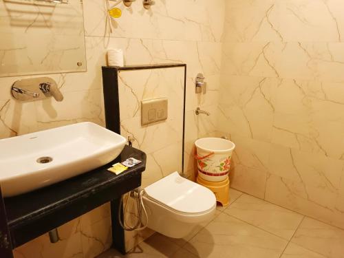 uma casa de banho com um lavatório e um WC em Hotel Tark Plaza Near IGI Airport Delhi em Nova Deli