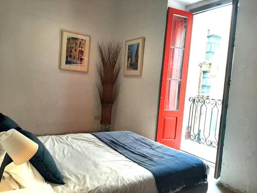 een slaapkamer met een bed en een rode deur bij Valletta Maisonette Malta in Valletta