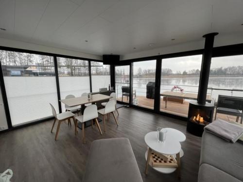 a living room with a table and chairs and a fireplace at Hausboot Bakerman in Zehdenick