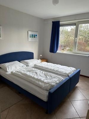 two beds sitting in a bedroom with a window at Loeiboei in Buren
