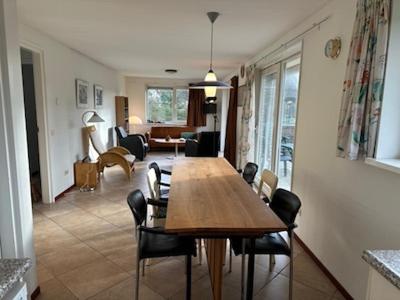 a living room with a wooden table and chairs at Loeiboei in Buren