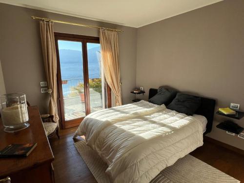 a bedroom with a bed and a large window at Pellegrini Boutique Villa Lake View in Verbania