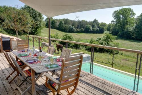 a table and chairs on a deck with a view at Le Petit Paradis in Saint-Pompain