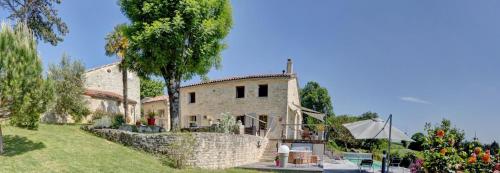 une vieille maison en pierre avec une clôture et des arbres dans l'établissement Le Petit Paradis, à Saint-Pompain