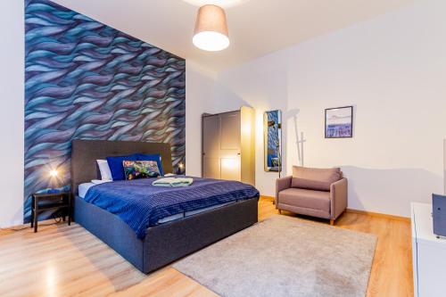 een slaapkamer met een bed en een stoel bij I.K.Apartments in Boedapest