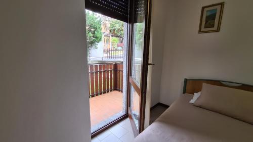 a bedroom with a bed and a glass door to a balcony at Albergo Meublé Aurora in Edolo