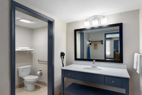 a bathroom with a sink and a toilet and a mirror at Days Inn by Wyndham Carlisle in Carlisle