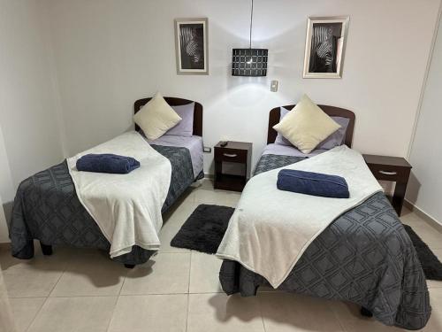 a room with two beds and two pillows at Departamentos estudio centro quillota in Quillota
