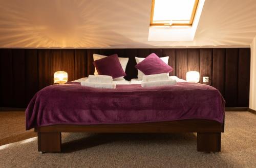 Hotel Hetman في كروتشيسته: غرفة نوم مع سرير أرجواني مع ملاءات ووسائد أرجوانية