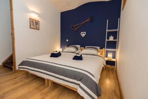ein Schlafzimmer mit einem großen Bett mit einer Uhr an der Wand in der Unterkunft Maison Lennox in Mâcot La Plagne