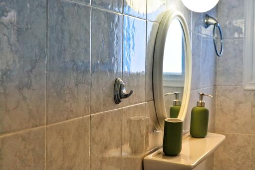 een badkamer met een wastafel en een spiegel bij Anatoli Sikinos in Síkinos