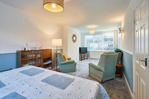 a bedroom with a bed and two chairs and a window at Host & Stay - St Mark's Close in Marske-by-the-Sea